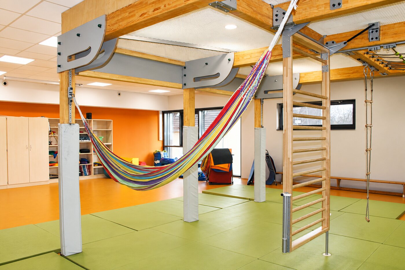 Bewegungsraum einer Grundschule mit Kletternetz, Sprossenwand und Hängematte